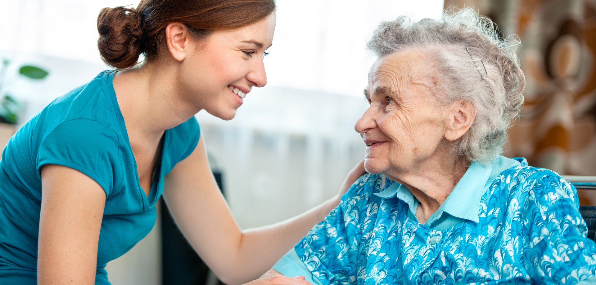 Altenpflergerin unterhält sich mit Seniorin