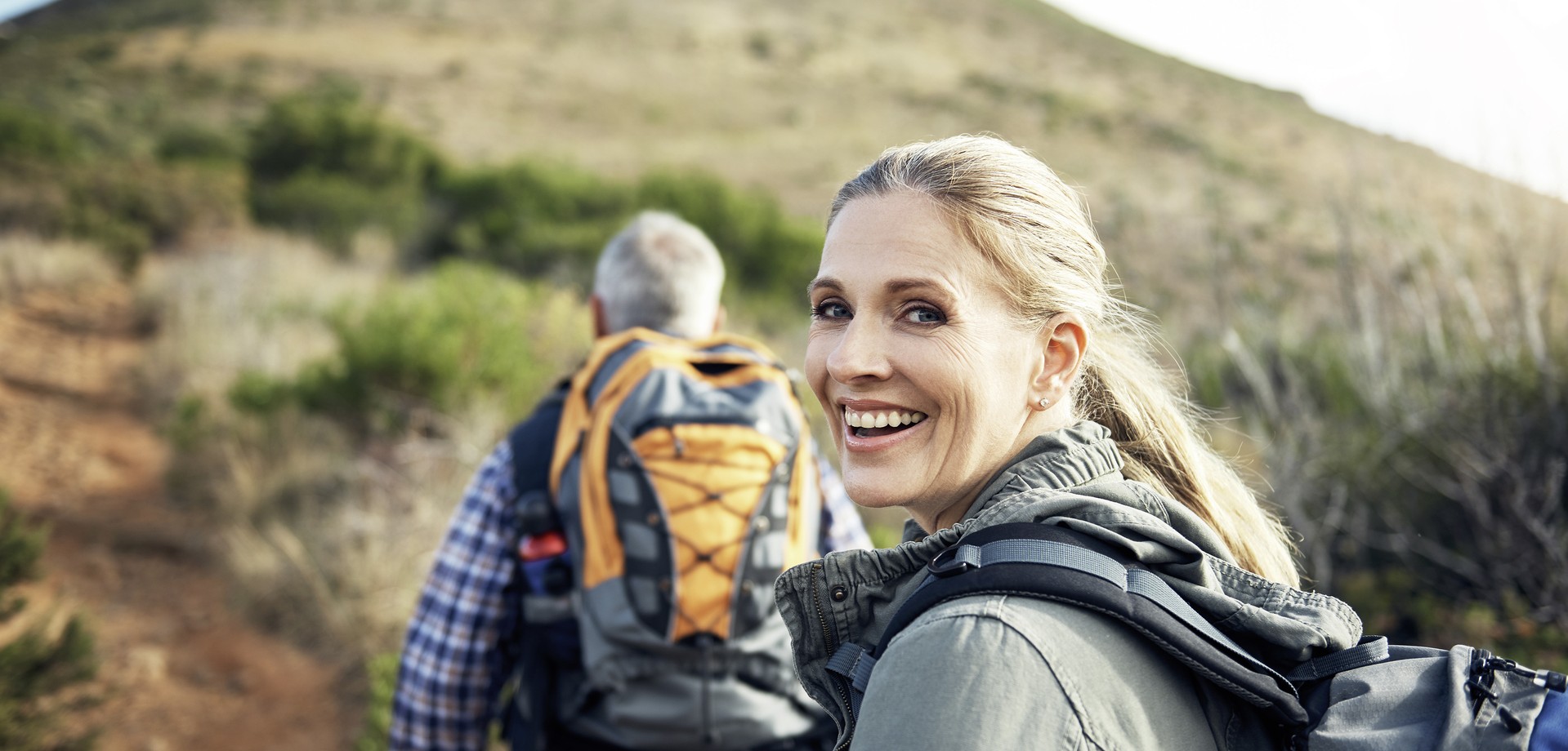 Frau auf Wanderung lächelt in die Kamera