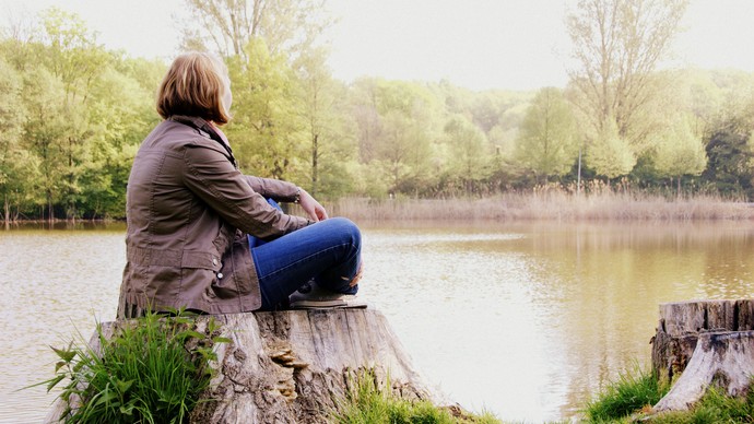 Eine Frau blickt auf einen See.