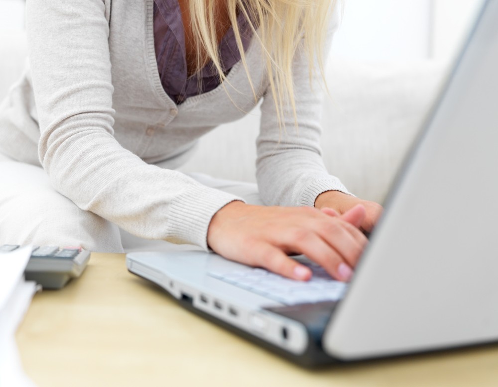 Frau tippt auf einem Laptop. Sie recherchiert auf der kvw-Internetseite.